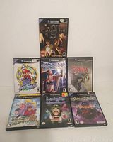 Seven Nintendo GameCube game cases arranged in two rows, front covers visible including Resident Evil Zero, Super Mario Sunshine, Phantasy Star Online, The Legend of Zelda: Twilight Princess, Tales of Symphonia, Luigi's Mansion, Viewtiful Joe