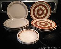 Front view of all plates and bowls arranged with some stacked by design