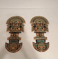 Two copper and teal colored Peruvian wall plaques with detailed figure designs