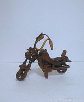 Front angled view showing detailed carving of motorcycle body and raised handlebars.