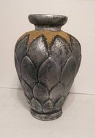 Front view of the grey handmade pottery vase with gold beaded geometric design showing petal-like body sculpting.