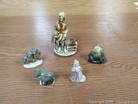 Photo showing five Wades tea figurines on a table, including oversized Molly Malone and four smaller character figurines