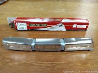 Three connected silver tin train cars with original box in background, train laid out straight on wooden surface.