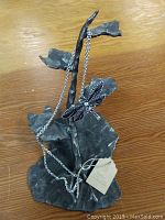 Photo of dragonfly necklace draped on heavy metal nature sculpture showing overall lot contents.