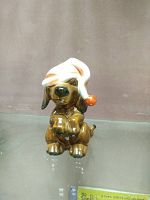 Front view of the Goebel West German brown dog figurine wearing white sleeping cap with orange pom-pom.