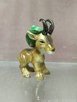 Front view of the Goebel West German animal figurine with black curved horns and green leaf detail