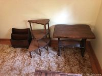 Wide shot showing all three items in the lot against a wall on carpet: corner shelf, side table, and magazine rack.
