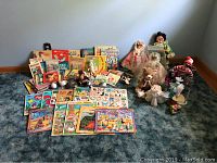 Overview of toddler toys, plush dolls, and assortment of children's books stacked and displayed on floor