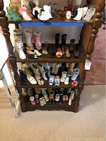 Full view of wooden shelf with multiple small collectible shoes made of wood and ceramic