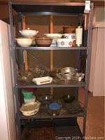 Full shelf view showing multiple Pyrex bowls, glass baking dishes and straw dispenser