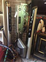 Photo showing the complete Sharper Image audio system with main unit, speakers and subwoofer in a home setting.