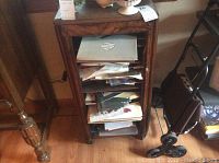 Front view of wooden sheet music stand filled with various sheet music and stationery items.
