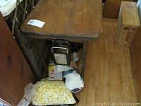 Photo of vintage wooden sewing table showing fold-down top and storage underneath with nicks on finish.