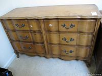 Full view of the 6 drawer wooden dresser showing curved drawer fronts and carved legs.