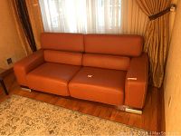 Front full view of tan leather sofa showing three seats, smooth upholstery, and silver legs