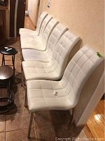Six chairs in a row showing tufted seats, backs and legs