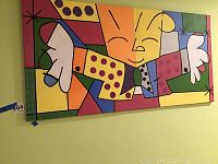 Full view of large hand-painted wall art showing smiling cartoon character with wide arms in colorful geometric pattern
