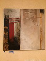Square canvas wall art with abstract neutral and red tones hung on wall to show size.