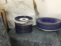 Two stacks of blue and white dishes showing the patterned design on top one plate of each stack.