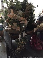 View of faux flower arrangement, lighted table tree, greenery hanging piece, and faux candles with greenery on a table.