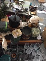 Photo showing most of the trinket boxes placed on a table with other items like glassware and kitchenware around