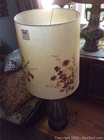 Full view of 41-inch lamp showing large cylindrical lampshade with pressed floral and foliage designs, cream background.