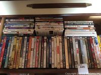Photo showing multiple DVDs in a drawer arranged horizontally, titles visible such as Avatar, Noha, Crash, Madagascar