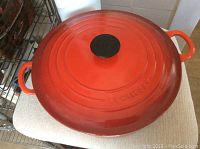 Top view of larger red enameled cast iron Dutch oven with lid