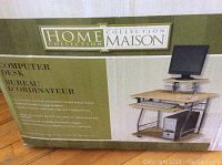 Box with label showing Home Collection Maison computer desk details including metal frame, wood finish surfaces, and keyboard tray.