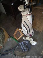 Set includes RH Callaway golf clubs in bag, white ladies golf shoes, wooden badminton racket, three HEAD tennis rackets, and wooden baseball bat.