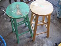 View showing both stools side by side, green painted stool on the left and natural wood stool on the right.