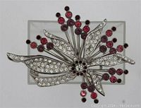 Front view of the vintage flower spray brooch showing clear crystal rhinestones on leaves and pink ruby rhinestones in round clusters on silver-tone metal.
