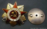 Front view of authentic Russian Soviet WWII Order of the Patriotic War 1st Class medal with enamel design, hammer and sickle, and sunburst.