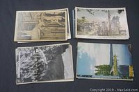 Four stacks of vintage postcards laid out for display. Cards depict various landscape and historic scenes from Victoria and Vancouver Island, including statues, garden and forested areas.