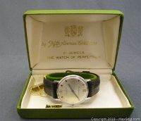 Full view of watch inside original green box with inner cream lining and gold text.