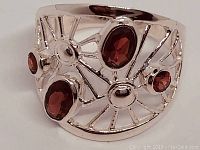 Front view of the ladies sterling silver ring showcasing the four oval Pyrope garnet stones and intricate openwork silver design.
