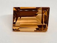 Top view of the bright golden citrine gemstone showing emerald cut facets.