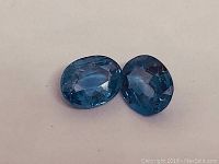 Photo showing pair of oval modified mixed cut blue sapphires, no heat treatment, total carat weight 1.64ct.
