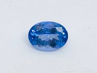 Close-up front view of oval indigo tanzanite showing modified mixed cut facets and vibrant blue color.