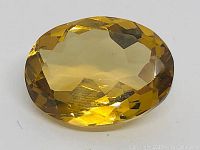 Close-up image of the natural golden yellow citrine gemstone showing oval modified mixed cut facets and vibrant color.