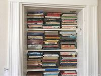 Bookshelves densely packed with approximately 60 books on Asian studies, visible titles on Confucianism, Hinduism, Tibetan, Chinese, and Indian philosophy and religion.