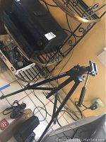 Photo shows Velbon tripod with adjustable legs and mounting head, black color.