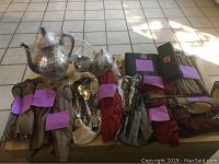 Overview of all flatware pouches, boxes and silver plated tea set on tiled floor