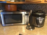 View of GE microwave oven, Power Pressure Cooker XL, and paper towel holder on kitchen counter.