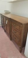 Front-side view of long wooden dresser showing three drawers on right and cabinet on left with handle.