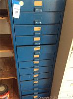 Front view of blue steel storage cabinet with 13 drawers