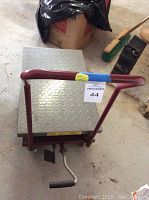 Front-angle view showing diamond plate platform, handle, and lot label