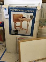 Photo of the original box showing the Winsome Wood 5-piece TV table set with natural finish.