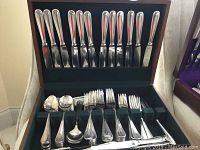 Top tray of wooden case with 12 stainless steel knives, bottom tray compartments empty