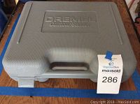 Closed gray molded plastic carrying case with Dremel Contour Sander embossed on lid